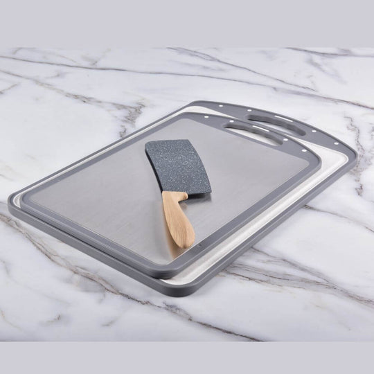 Kylin 316 stainless steel double side cutting board with smooth surface and wooden handle spatula on marble countertop.