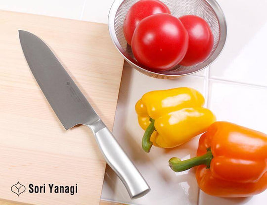 Yanagi Japanese Chef Knife on a cutting board with colorful bell peppers and tomatoes, showcasing quality and affordability.