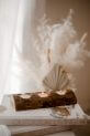 Tree candle holder with 3 holes on a table with decorative feathers, adding affordable luxury to your decor.