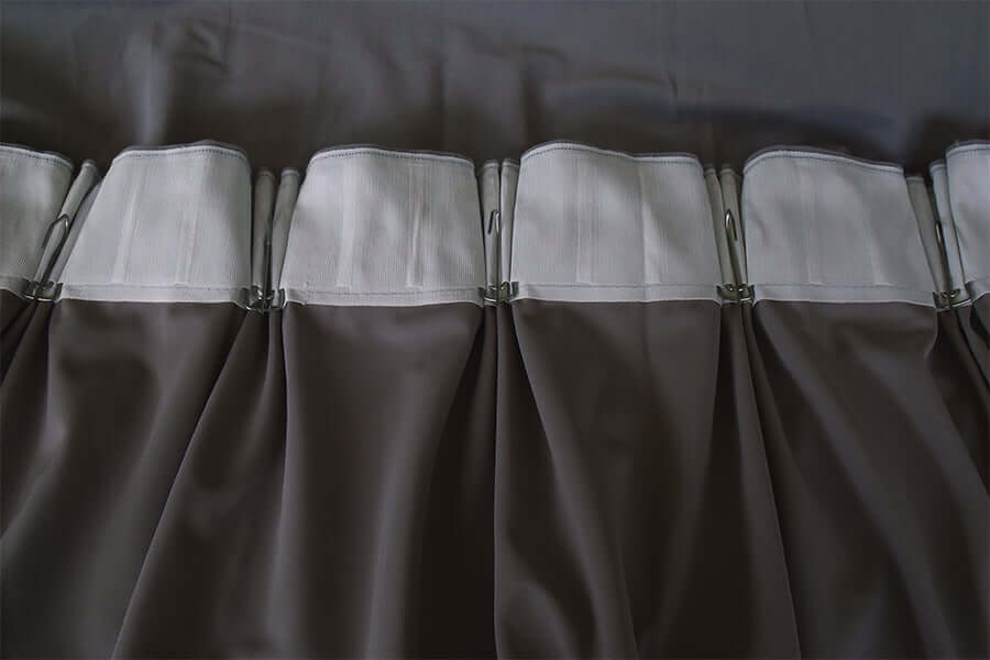 Close-up of pinch pleat design on thick velvet blockout curtains in purple grey with hooks for easy installation.