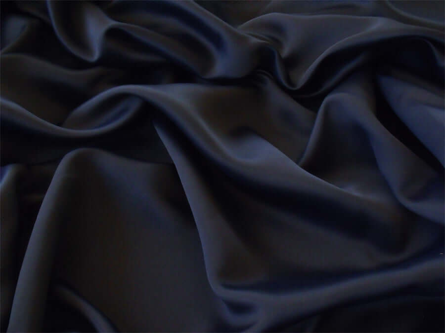 Luxe black 100% polyester blackout curtain fabric, wrinkle-resistant and soft with silk-like texture, perfect for affordable DIY projects.