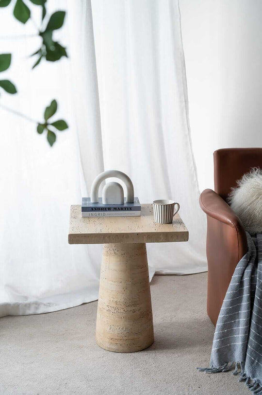 Modern Logan Cement Square Side Table in a stylish living room setup with books and a coffee cup.