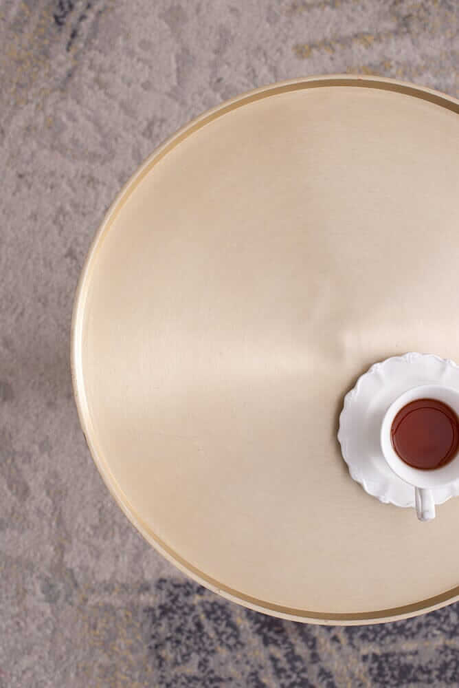 Top view of a luxe handmade side table with a cup of tea placed on it, showcasing its elegant marble and aluminum design.