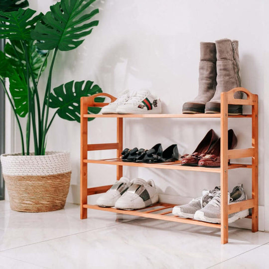 Bamboo 3-tier shoe rack organized with various shoes, enhancing modern home decor and storage efficiency.