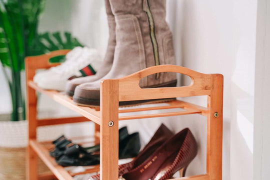 Bamboo 3-tier shoe rack displaying stylish boots and shoes, offering affordable and quality storage for modern homes.