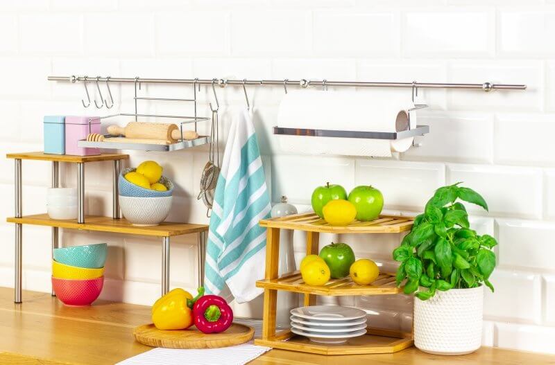 Stylish bamboo kitchen rack with colorful dishware and fresh produce, enhancing kitchen organization and space efficiency.