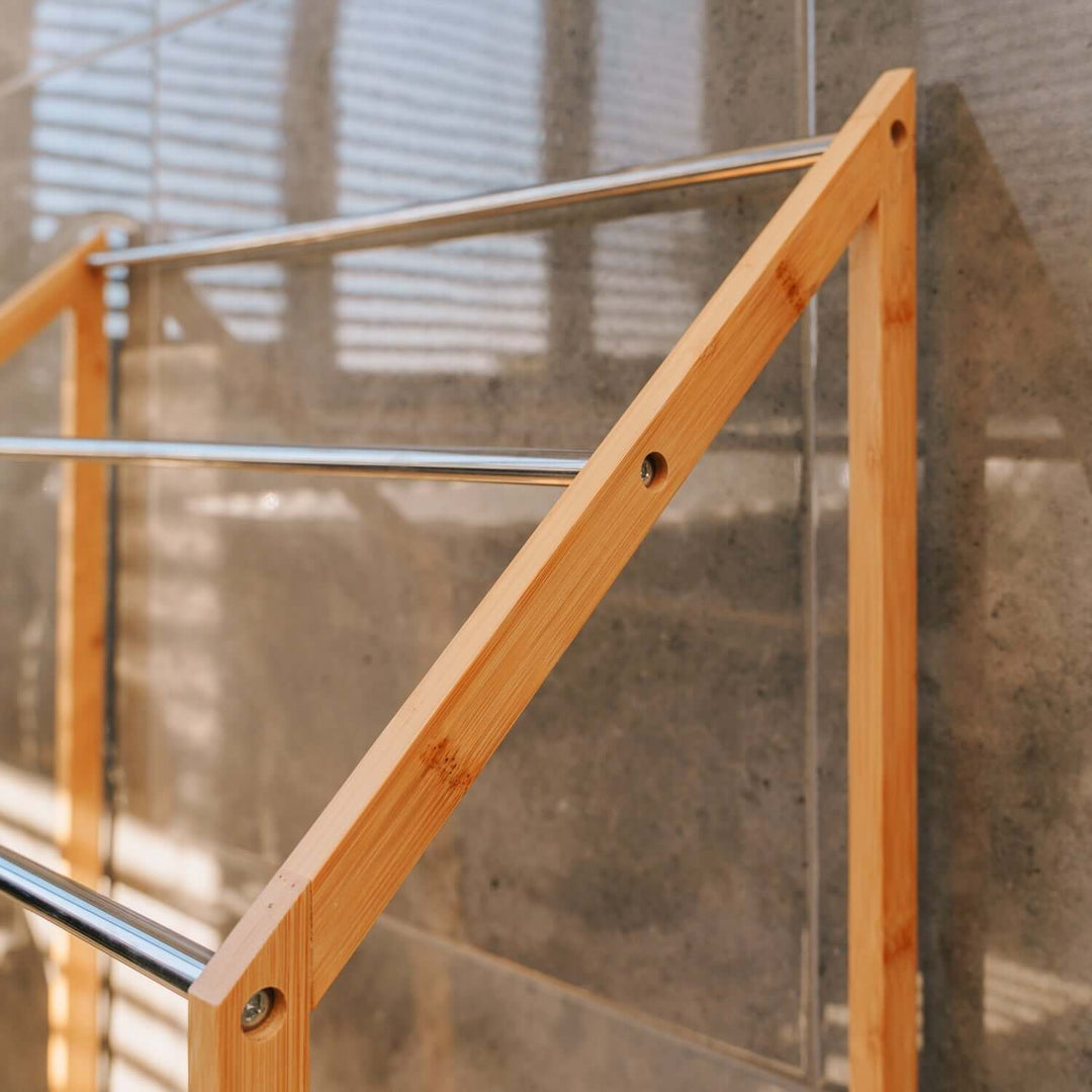 Close-up of bamboo towel rack showcasing sleek design and metal bars for a functional bathroom organizer.