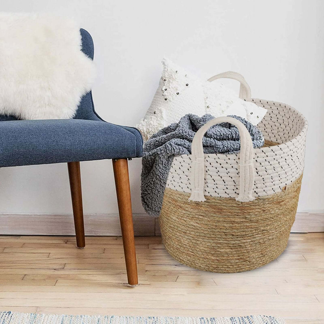 Affordable handmade cotton rope storage basket set with carry handles, stylishly placed beside a comfy chair.