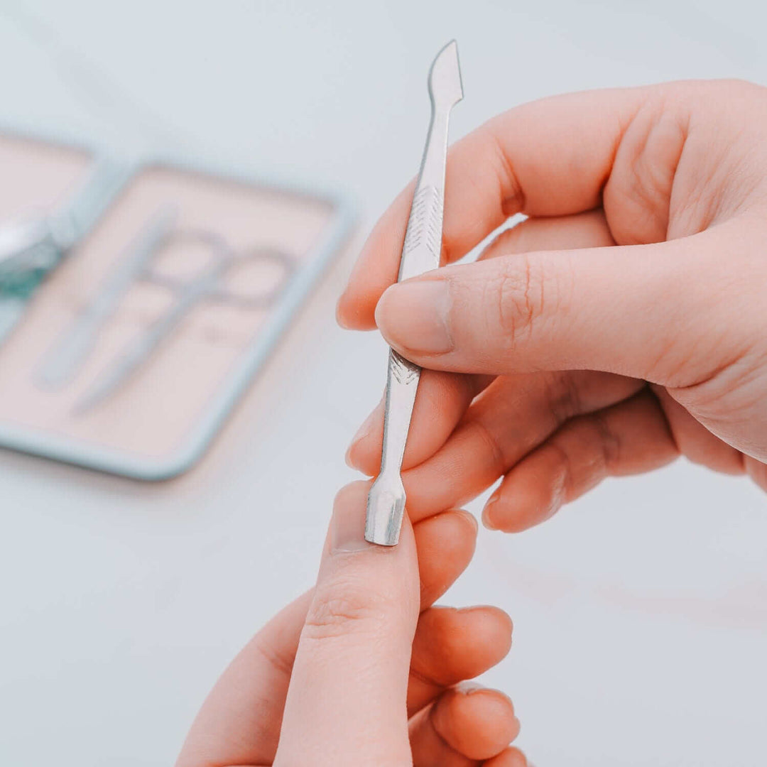 Remology stainless steel manicure tool being used on nails, showcasing affordable and quality DIY personal care.