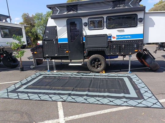 Spacious 5m x 2.4m recycled poly camping mat set up in front of a camper van for outdoor adventures.