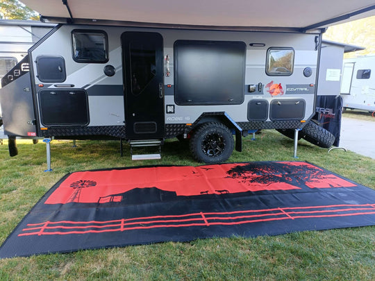 Spacious country-themed recycled mat laid out under a camper for enhanced outdoor comfort and style.