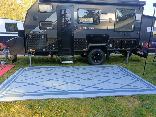 Spacious 5m x 2.4m recycled poly camping mat in front of a dual-axle camper van, ideal for outdoor adventures.