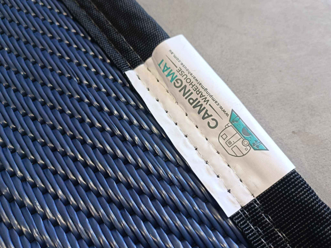 Close-up of the durable fabric and label on a 5m x 2.4m recycled poly camping mat for outdoor adventures.