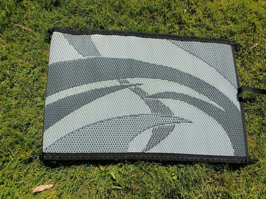 Swish Grey 5m x 2.4m recycled poly camping mat on grass, showcasing a lightweight and durable design for outdoor use.