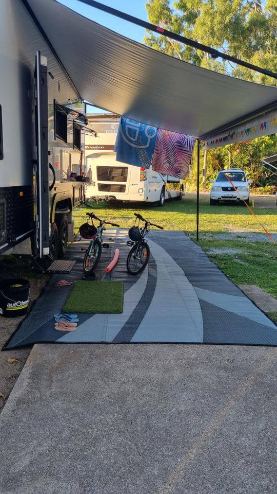 Outdoor setup with Swish Grey recycled poly mat, bicycles, and a relaxing atmosphere under an RV awning.