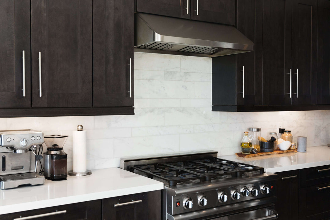 Modern kitchen with black cabinetry, stainless steel range hood, affordable DIY luxury design.