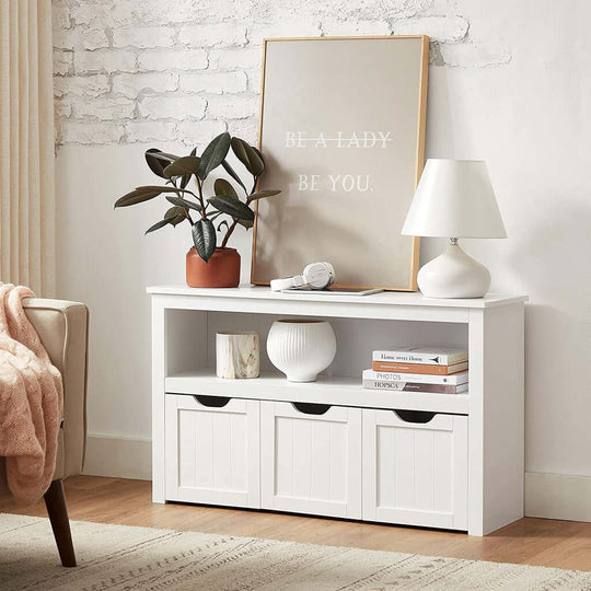 White VASAGLE storage bench with shelf, three drawers, books, lamp, and plant. Affordable, quality, DIY luxe furniture.