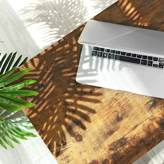 Open laptop on rustic wooden table with sunlight and plant shadows, showcasing affordable and quality homewares and value furniture.