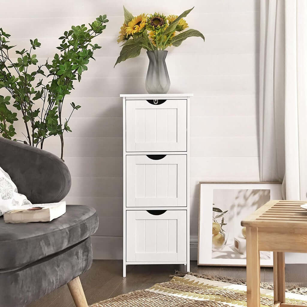 VASAGLE white floor cabinet with 3 drawers, Nordic style, vase with sunflowers on top in cozy living room setting. Affordable quality.