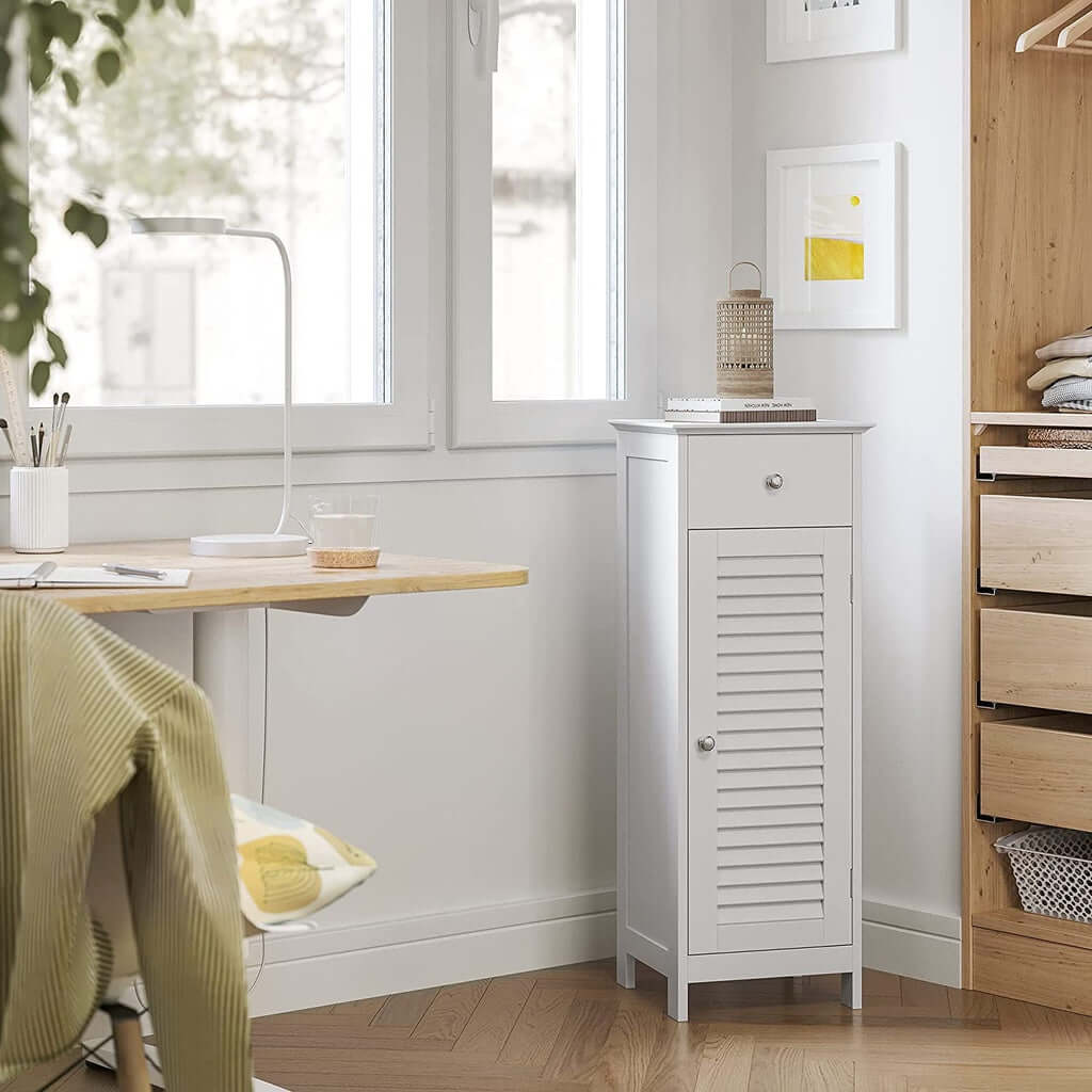 White VASAGLE floor cabinet with drawer and door in a cozy room corner, featuring affordable quality and DIY luxe design.