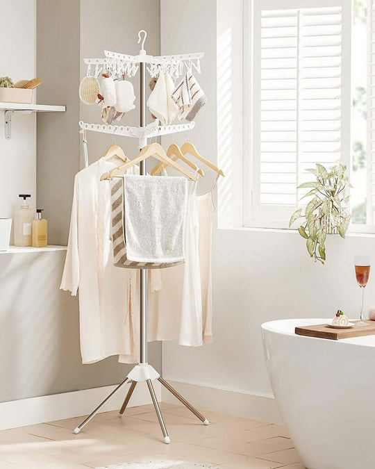 SONGMICS 2-Tier Clothes Drying Rack holding various garments in a bright, modern bathroom setting.