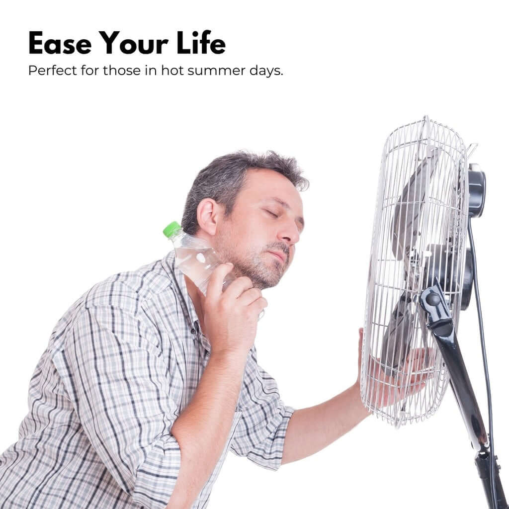 Man enjoying cool breeze from a fan while holding a water bottle, perfect for summer comfort.