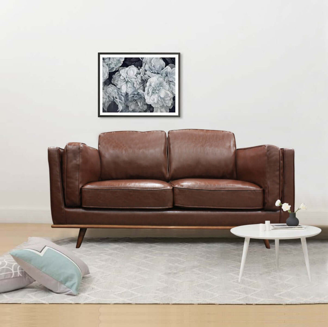 Brown 2-seater faux leather sofa in modern living room with wooden frame and comfy cushions, matching with contemporary decor.