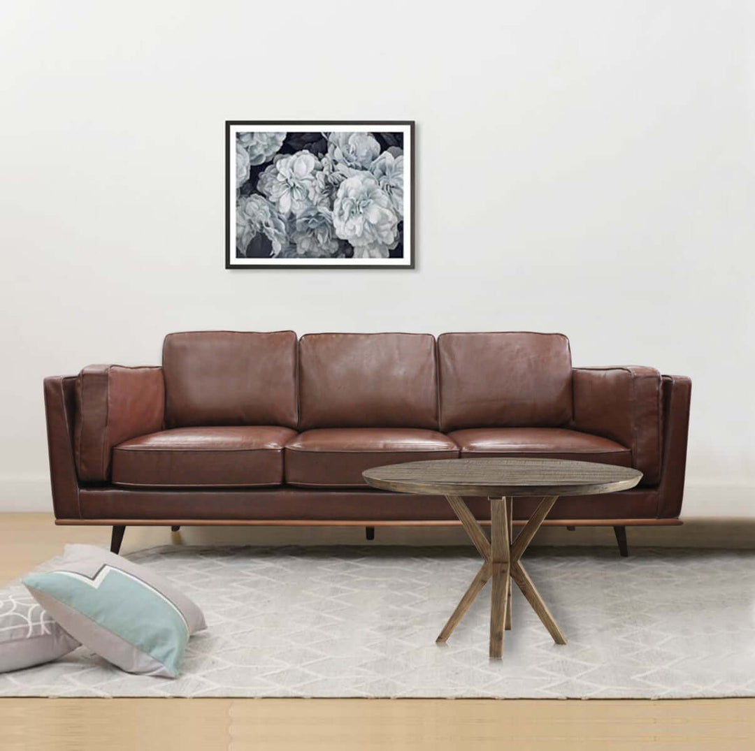 Brown faux leather 3 seater sofa with wooden frame, comfy cushions, and unique design in a living room setting with modern decor